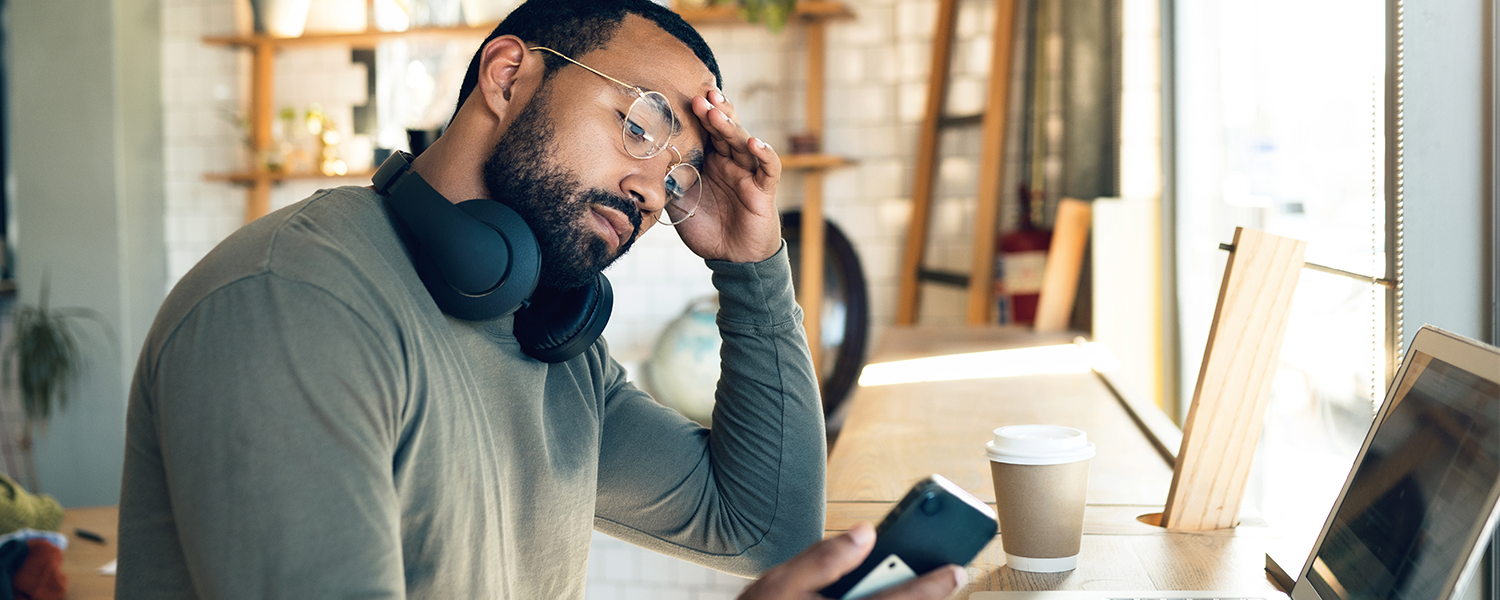 Man looking stressed looking at his phone