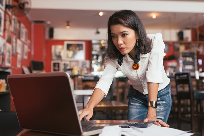 Woman standing up looking at laptop