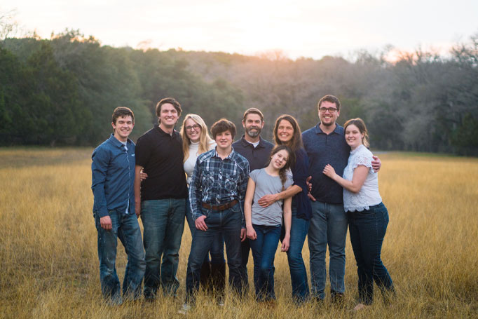 A family standing together in a field