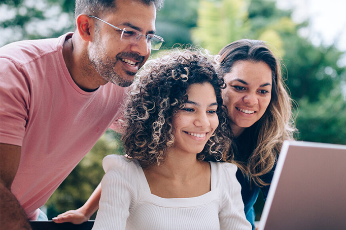 Parents and child looking at laptop for college information