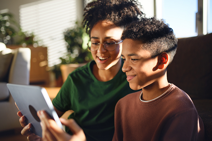 siblings looking at tablet