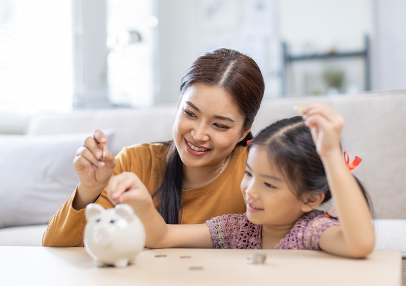 woman and daughter using a piggy bank